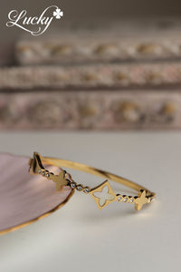 Brazalete dorado de aro con piedras pequeñas y diseño